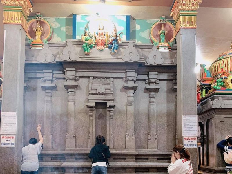 Chùa Bà Ấn Độ Sài Gòn: Khám Phá Kiến Trúc Hindu Linh Thiêng Giữa Lòng Thành Phố 8 Người dân đang úp mặt vào đá để cầu nguyện phước lành, cầu bình an tại Chùa Bà Ấn Độ linh thiêng