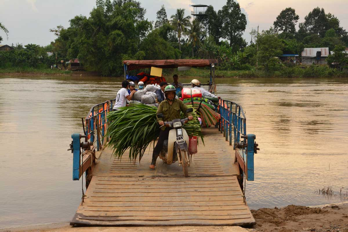 Người nông dân và xe máy trên phà qua sông Đồng Nai gần Cát Tiên