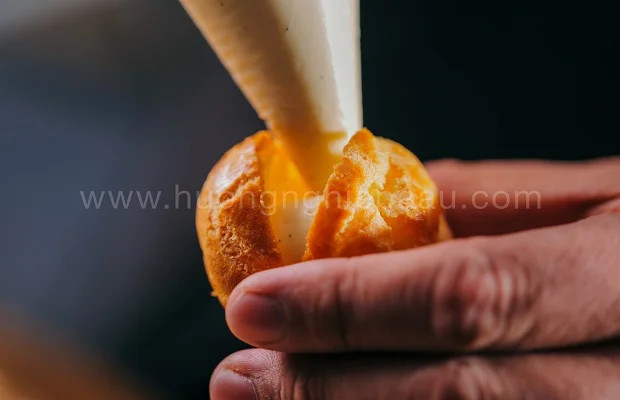 Khám Phá Công Thức Làm Bánh Su Kem Singapore Mềm Mịn, Thơm Ngon Chuẩn Vị 5 Bơm nhẹ nhàng phần nhân kem vào bên trong vỏ bánh su kem