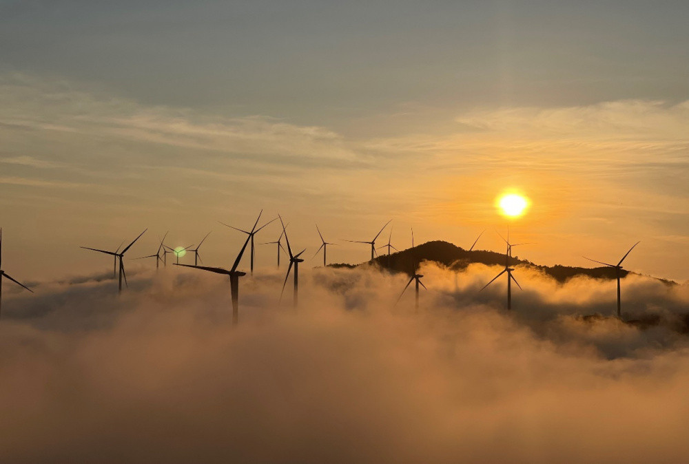 Cảnh hoàng hôn buông xuống trên cánh đồng điện gió Hướng Hóa, các tuabin nổi bật trên nền trời rực rỡ