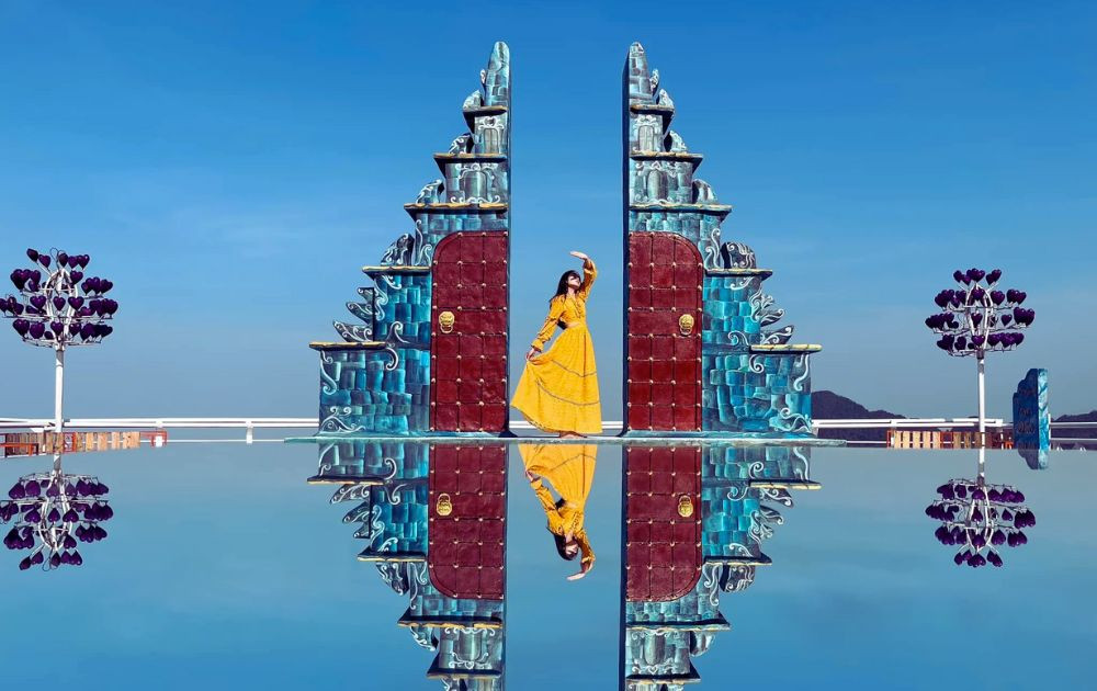 Một du khách nữ đang tạo dáng chụp ảnh tại khu vực Cổng trời Tam Đảo với cảnh quan núi non phía sau