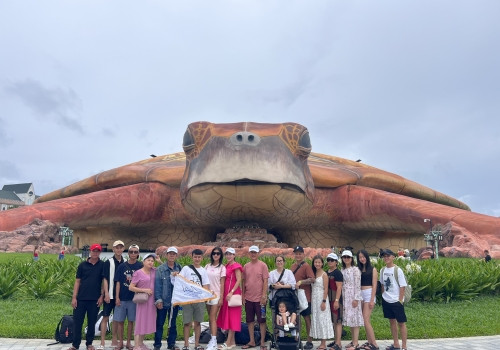 Một con thuyền lớn và những chiếc thuyền thúng nhỏ đang neo đậu trên bãi biển cát trắng dưới ánh nắng rực rỡ