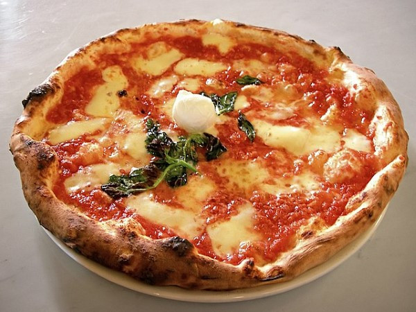 Bánh pizza đế mỏng với phô mai mozzarella tươi và húng quế