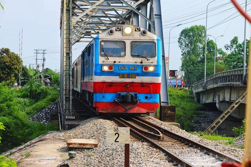 Toa tàu hỏa đang di chuyển, phía ngoài cửa sổ là khung cảnh thiên nhiên